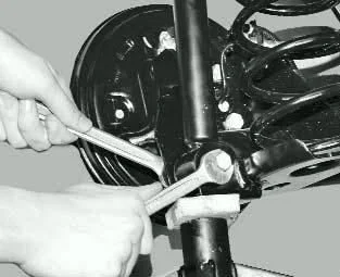 Отворачивание нижнего болта амортизатора Форд Фокус 1