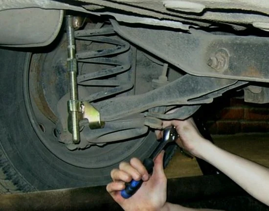 откручивание нижнего болта заднего амортизатора Фокус 1