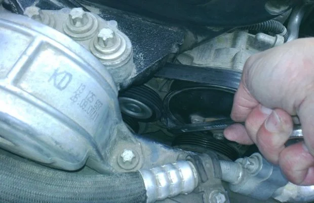 отводим натяжной ролик ремня генератора Astra H