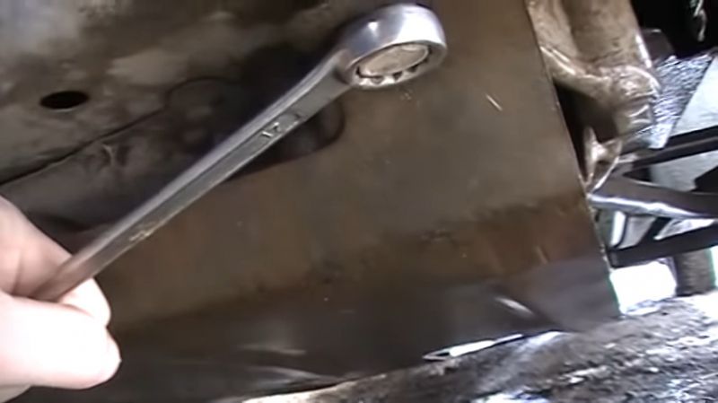 Откручивание болтов защиты двигателя Откручивание двух болтов защиты двигателя